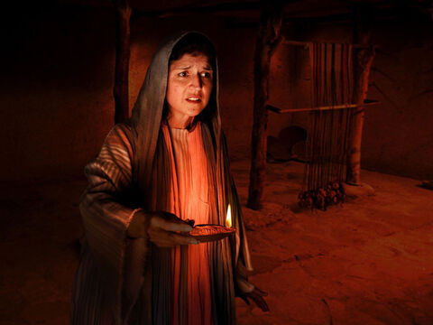 She lights an oil lamp and searches inside her house. – Slide 9